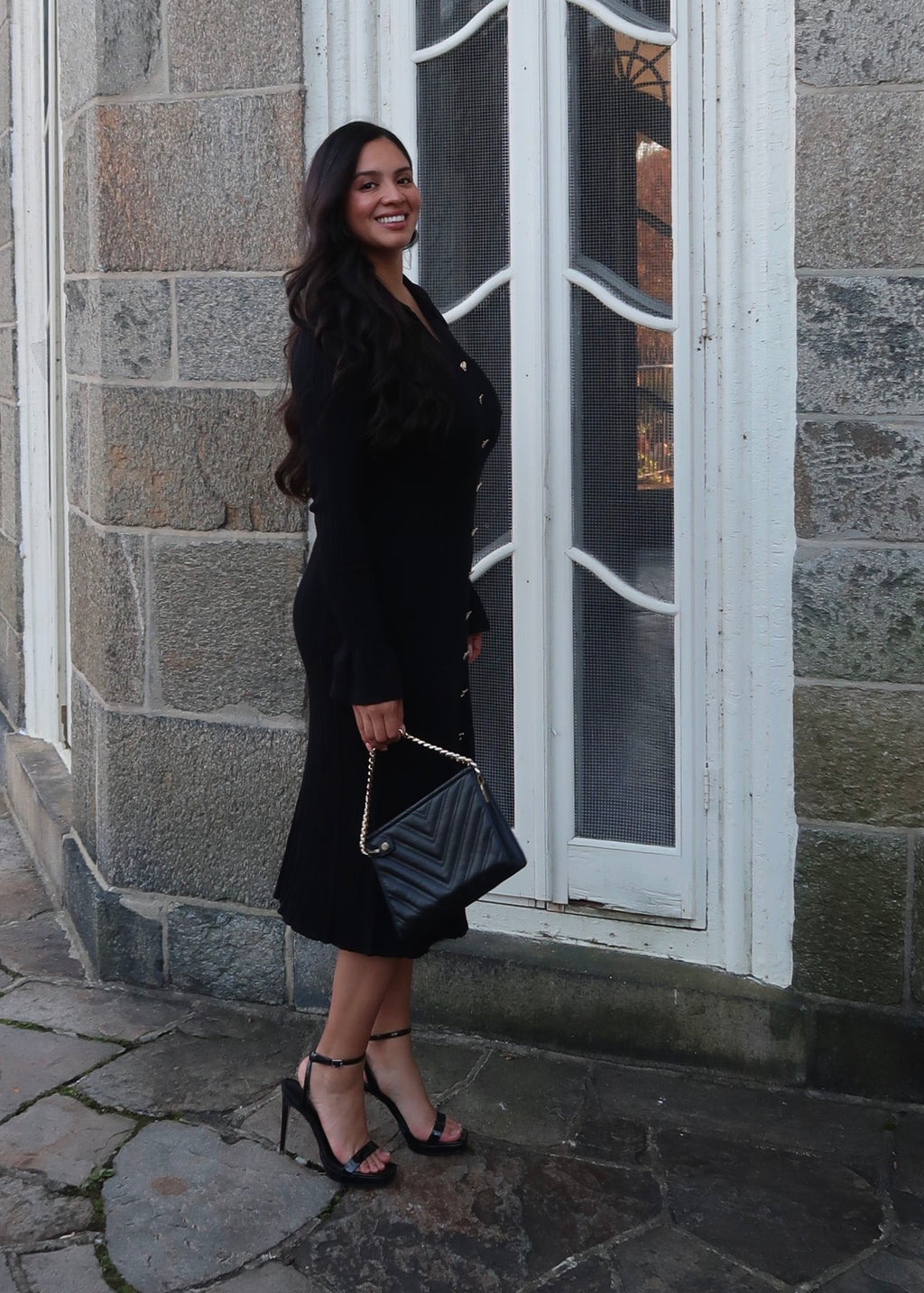 Black sweater dress, gold buttons, cuff sleeves, midi length, v-neck, collar