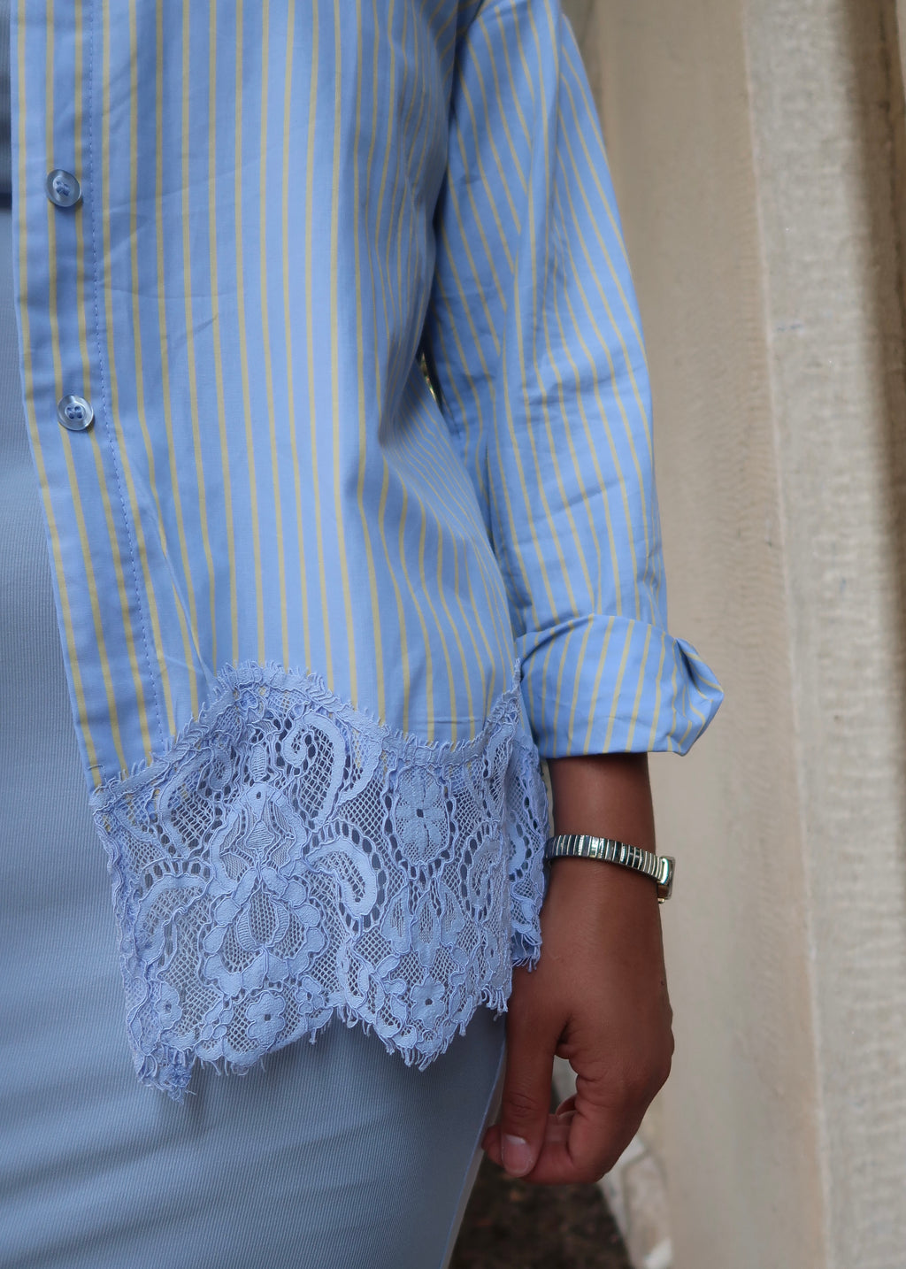 Blue and yellow pinstripe womens button down blouse, collared, lace hem, long sleeves, baby blue dress underneath, white heels 