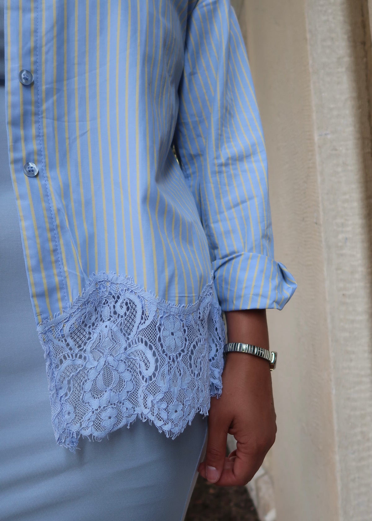 Blue and yellow pinstripe womens button down blouse, collared, lace hem, long sleeves, baby blue dress underneath, white heels 