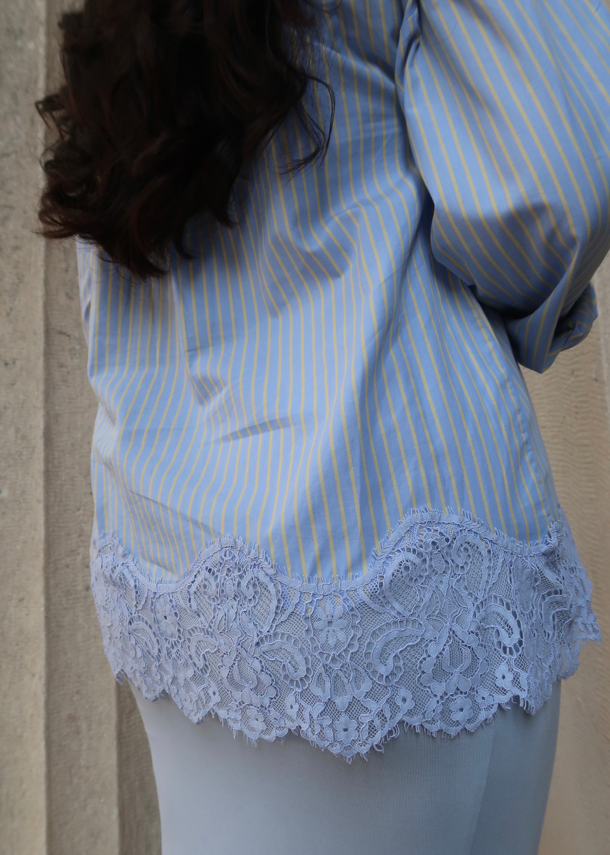 Blue and yellow pinstripe womens button down blouse, collared, lace hem, long sleeves, baby blue dress underneath, white heels 