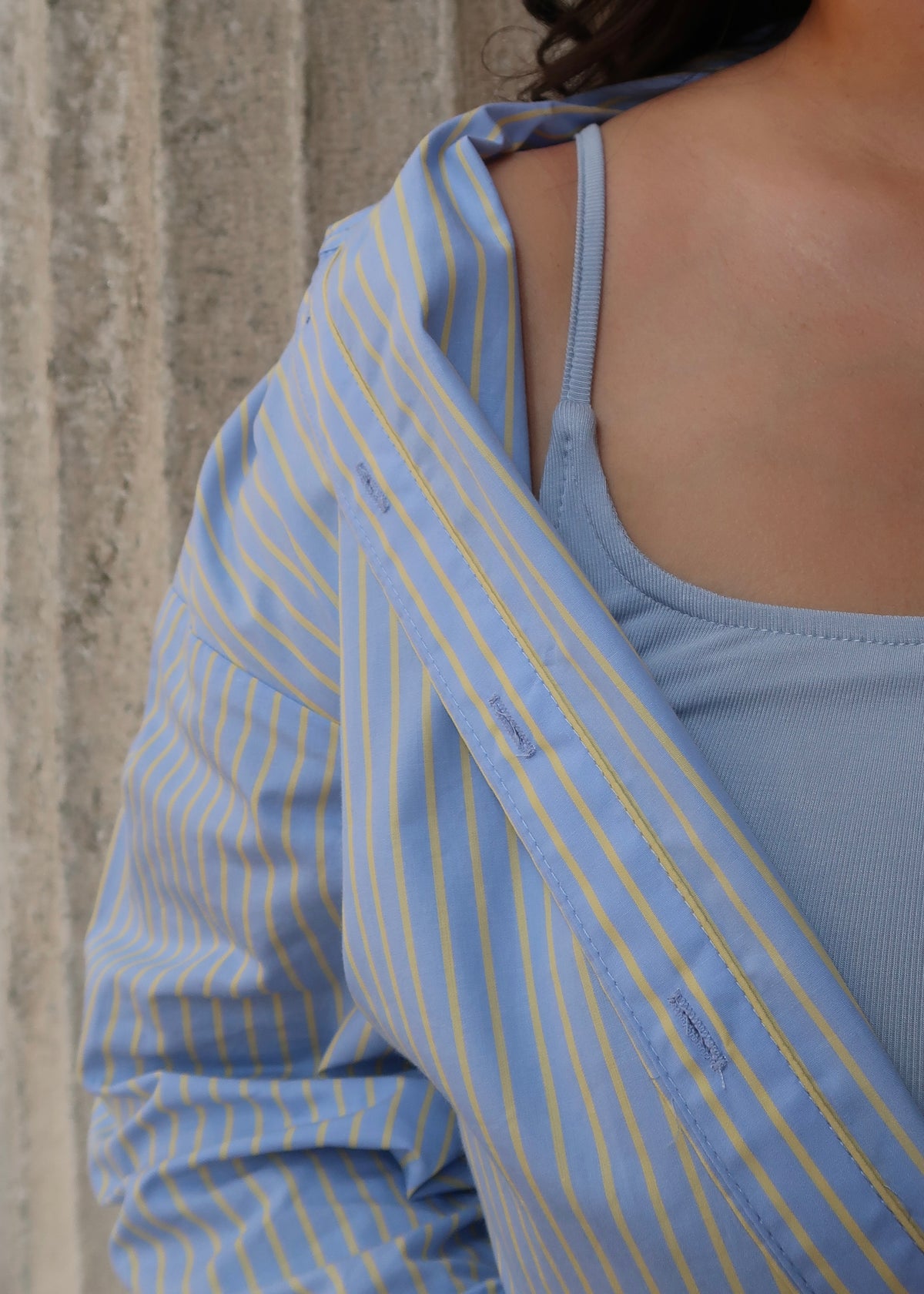 Blue and yellow pinstripe womens button down blouse, collared, lace hem, long sleeves, baby blue dress underneath, white heels 