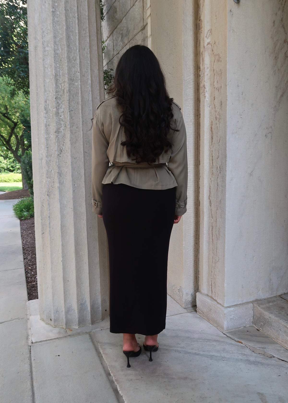Olive green cropped waist tie trench jacket with black skirt and buckled heels